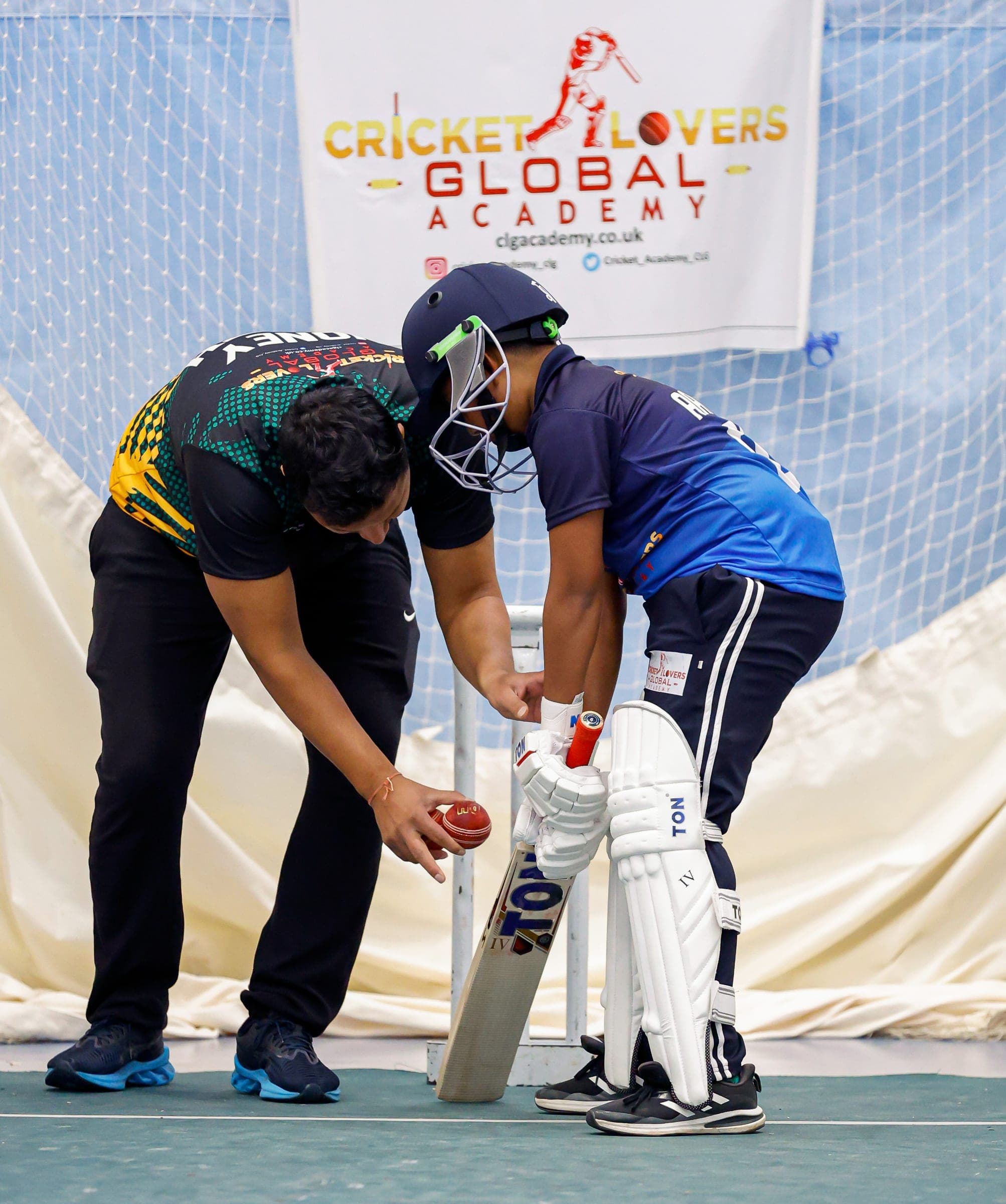 Coach working with a batter in the nets