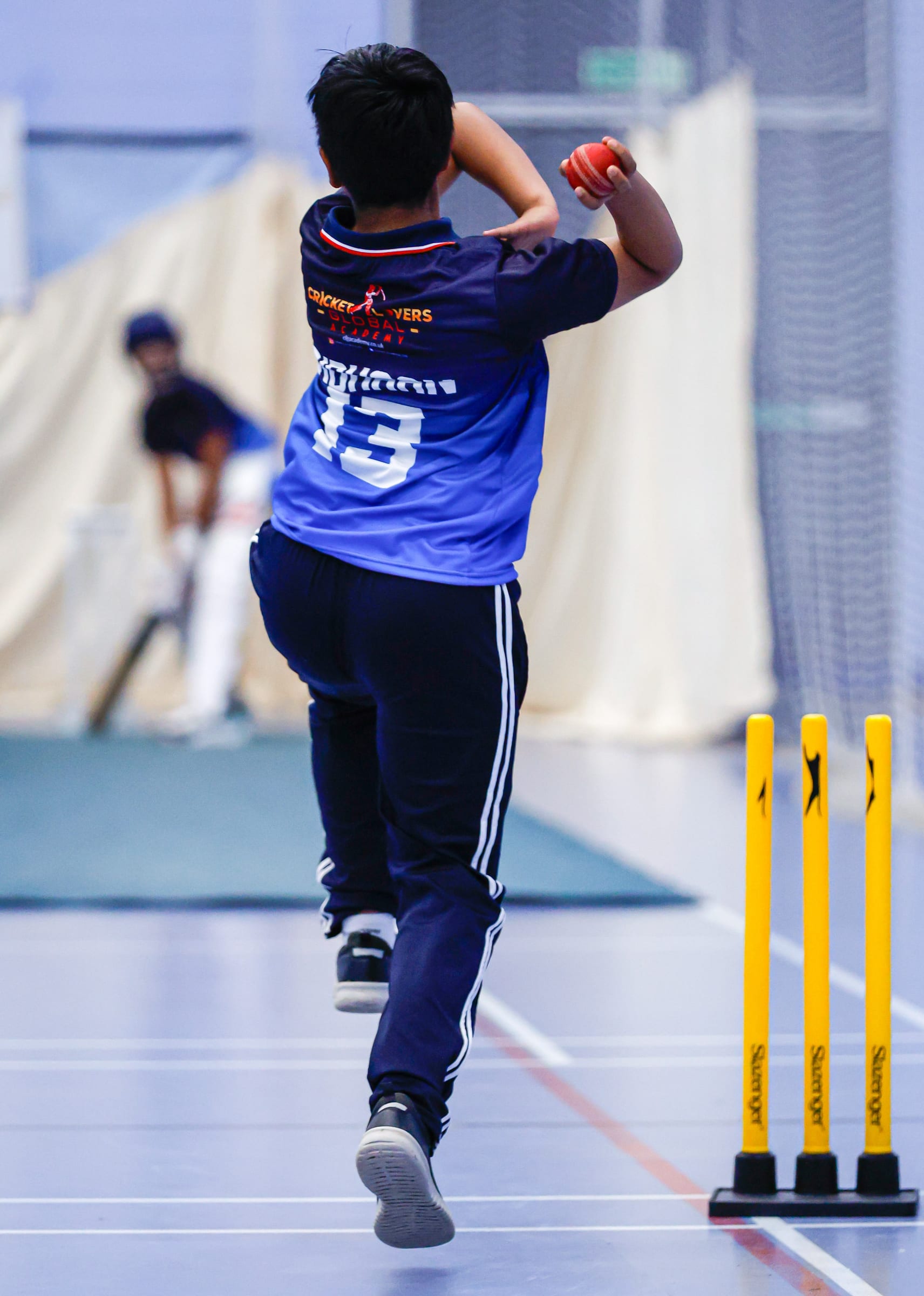 Boy bowling in academy kit